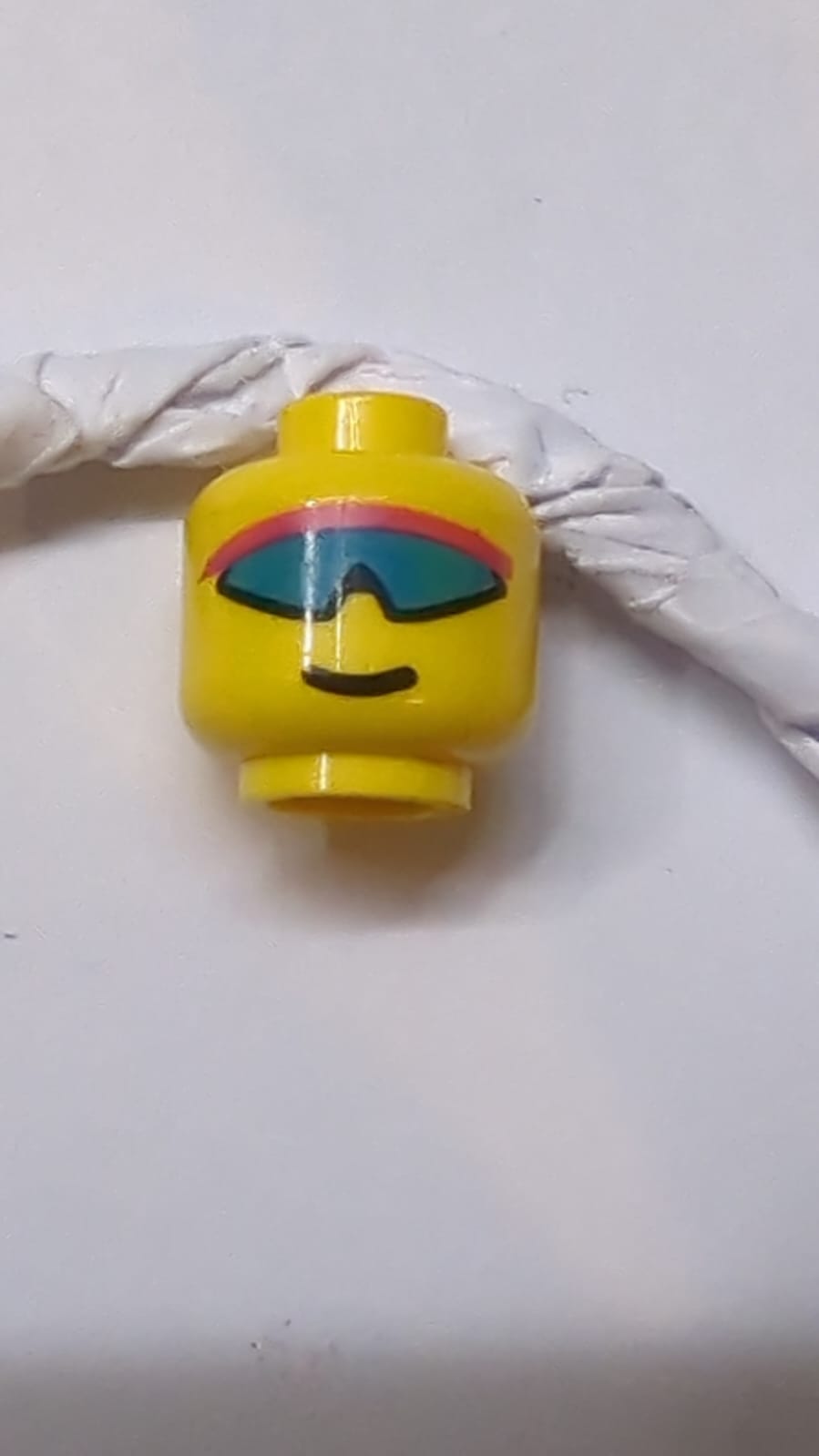 Kopf mit blauem und hellviolettem Tuch, Sonnenbrille, Grinsen-Muster gelb