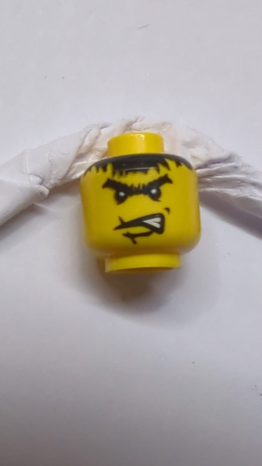 Kopf eines männlichen Charakters, Narbe über der Lippe, wütende schwarze Augenbrauen und unordentliches Haarmuster (Dracus) gelb