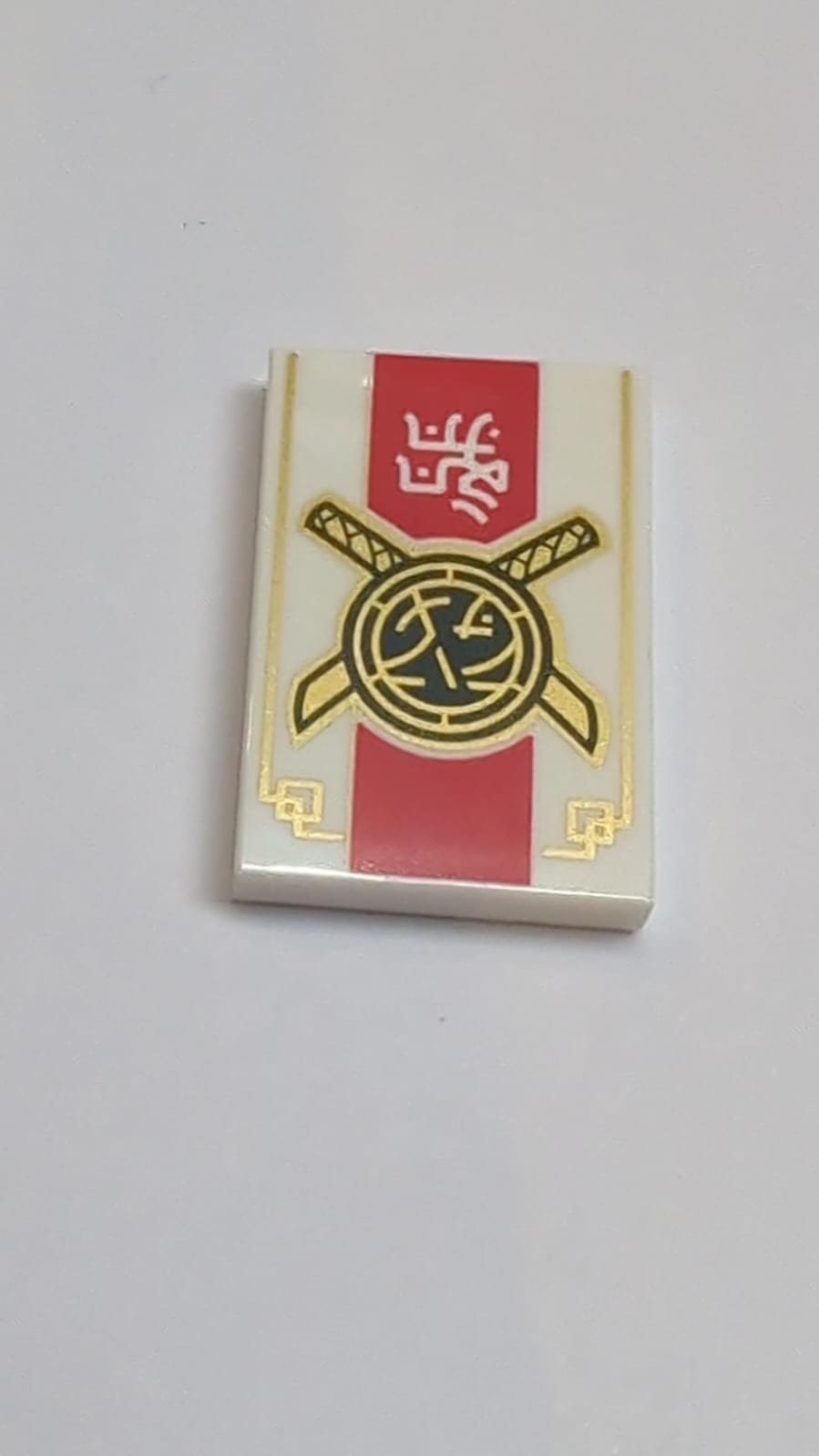 NEU Fliese 2 x 3 mit schwarzen und goldenen gekreuzten Schwertern und Core-Logo, weißes Ninjago-Logogramm 'DOJO', dicke rote Streifen und Goldrandmuster, weiß