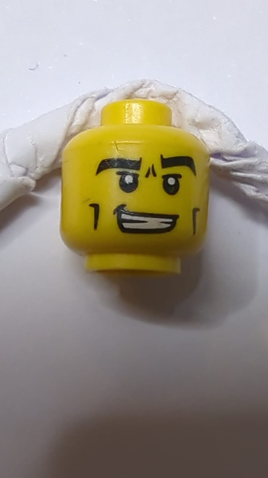 Minifigur, männlicher Kopf schwarz, dicke Augenbrauen, Wangenlinien und Stirnfaltenmuster gelb