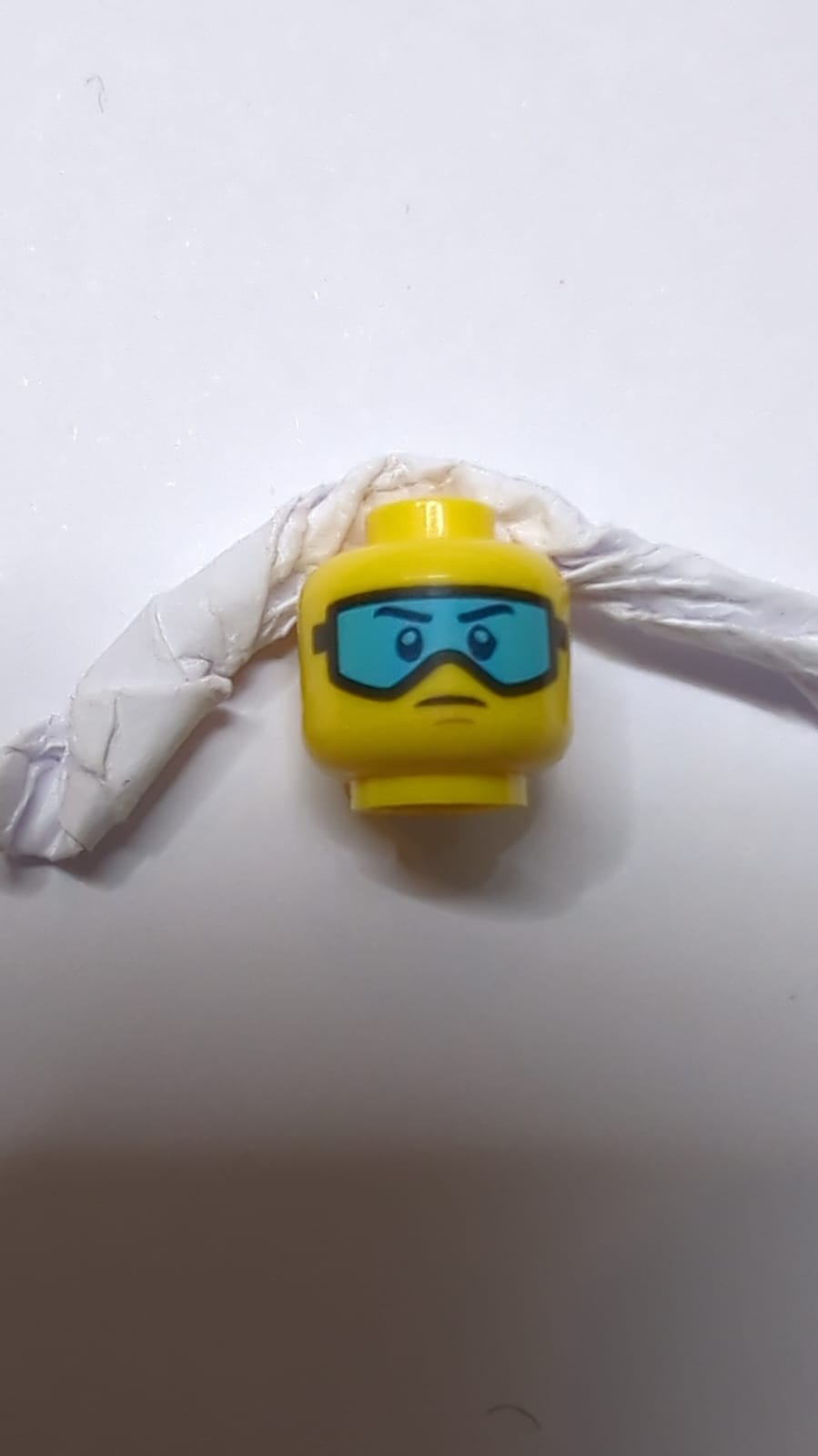 Kopf mit Brille, mittleren azurblauen Skibrille und leichtem Stirnrunzeln gelb