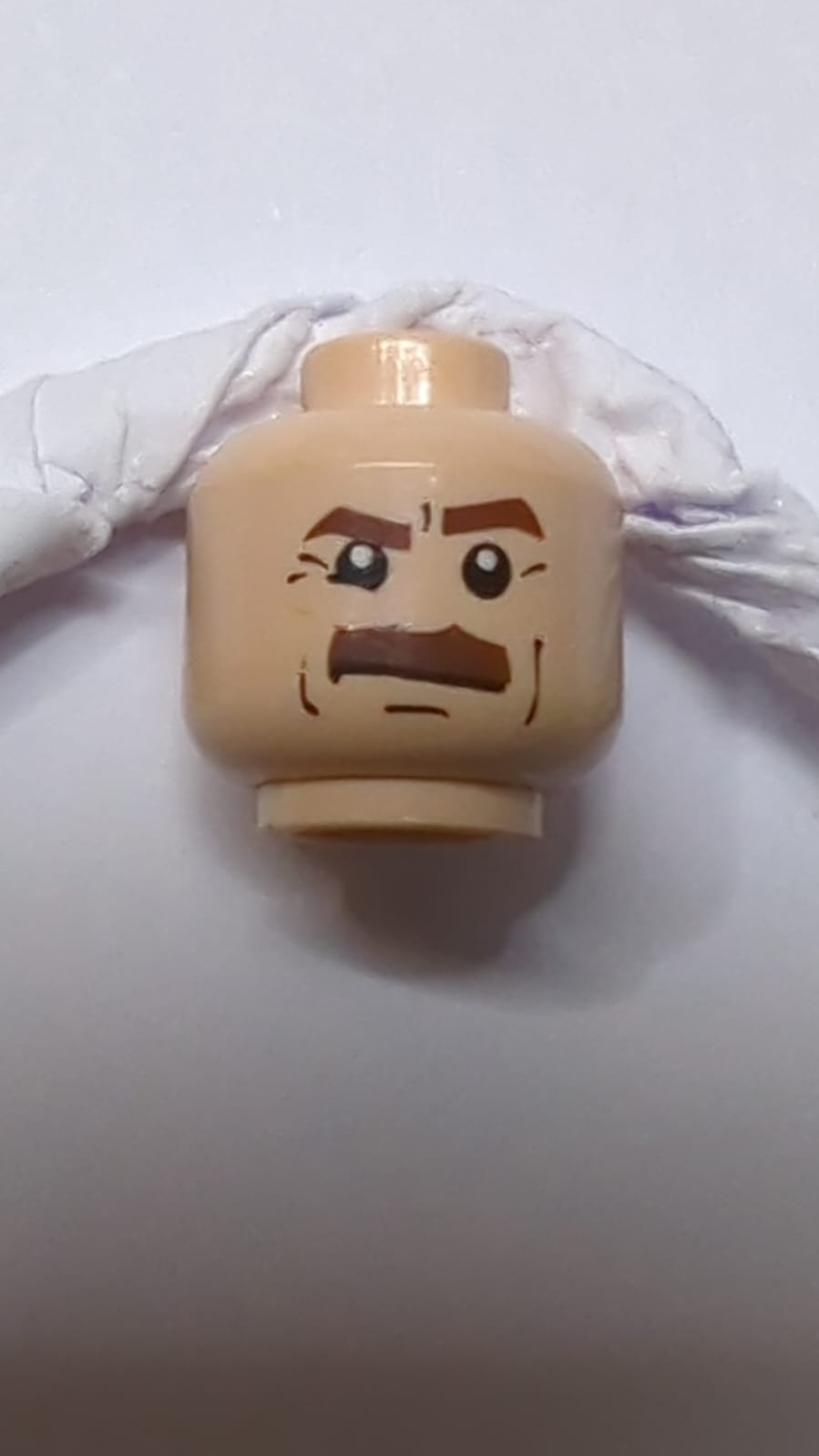 Kopf rötlich braun, dicke Augenbrauen und Schnurrbart, unteres rechtes Augenlid, schwarze Wangenlinien, Grübchen am Kinn und Falten, strenger Ausdruck nougat (hell)