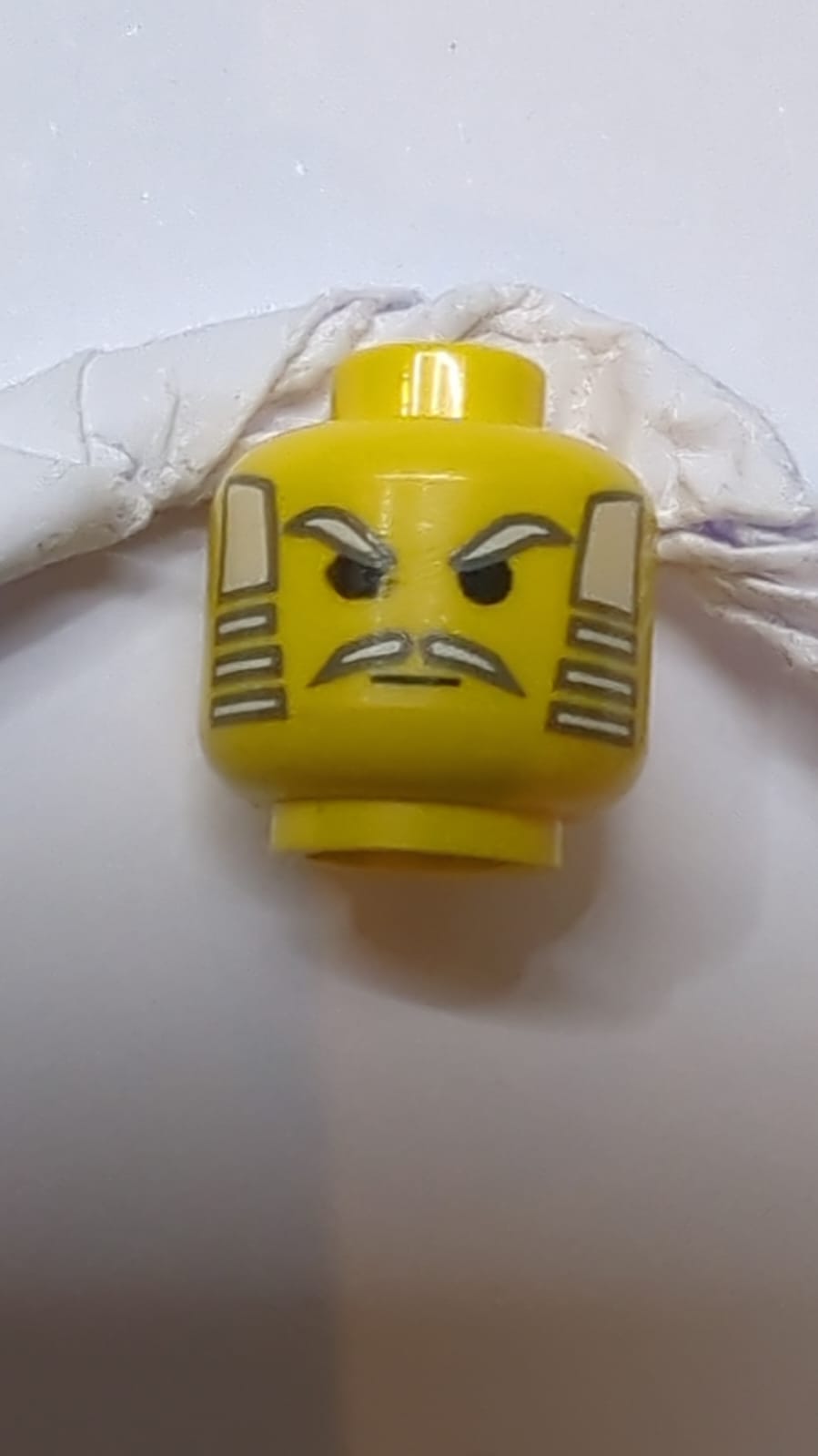 Kopf mit Schnurrbart, weißem Haar, Augenbrauenmuster gelb