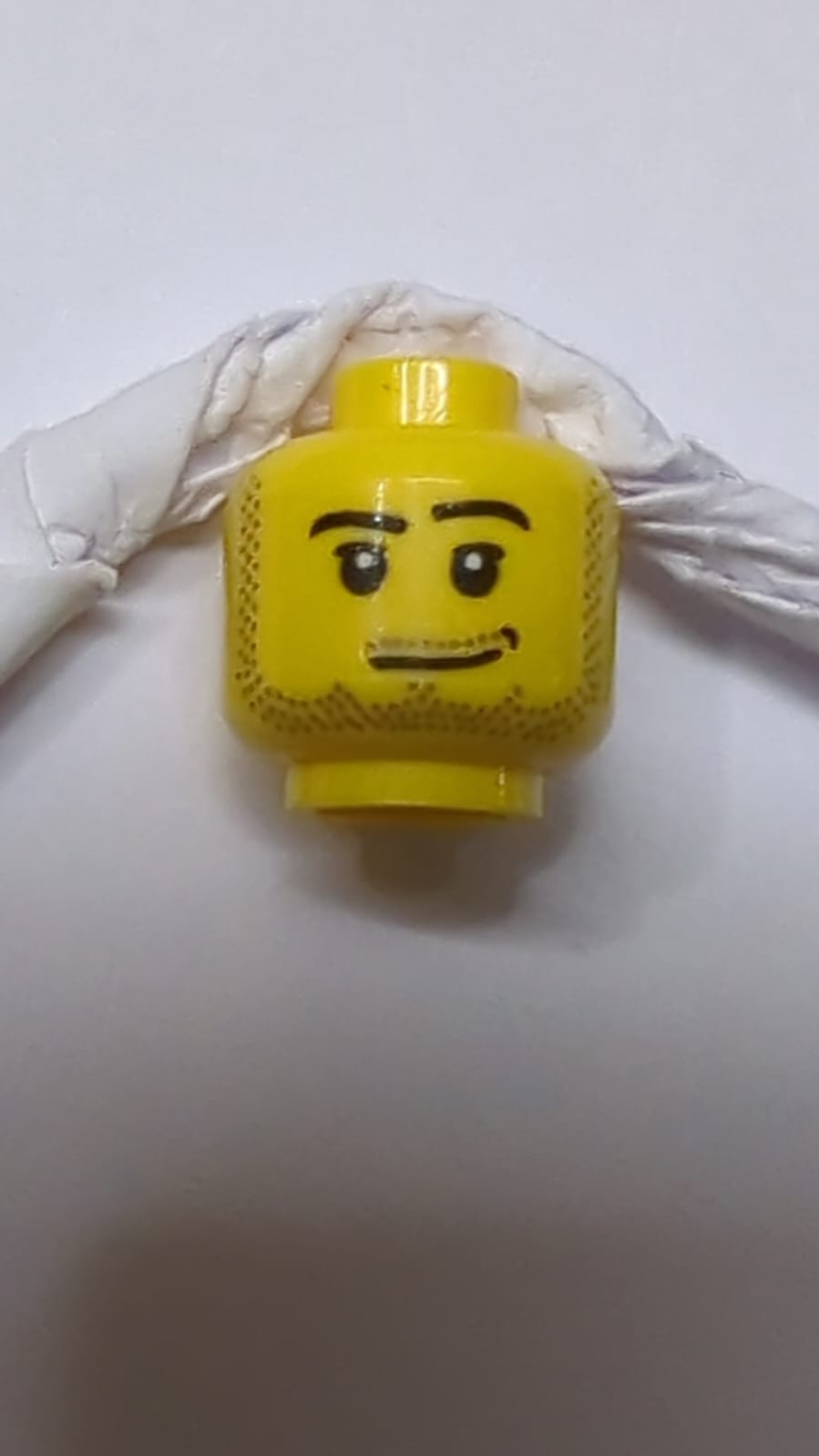 männlicher Kopf mit schiefem Lächeln, mittlerer Nuss-Narbendimple, Pupillen, dunkelblaugrauer Stoppelbart, Schnurrbart und Kotelettpattern gelb