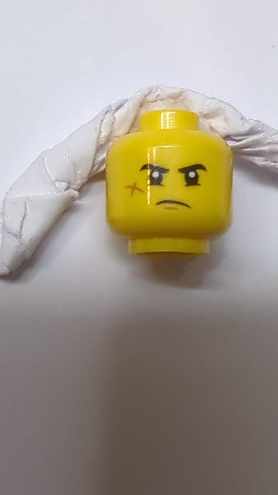 Minifigur, Kopf mit beidseitigen schwarzen Augenbrauen, Wangen-Narbe, großem Lächeln mit Zähnen / mürrischem Muster gelb