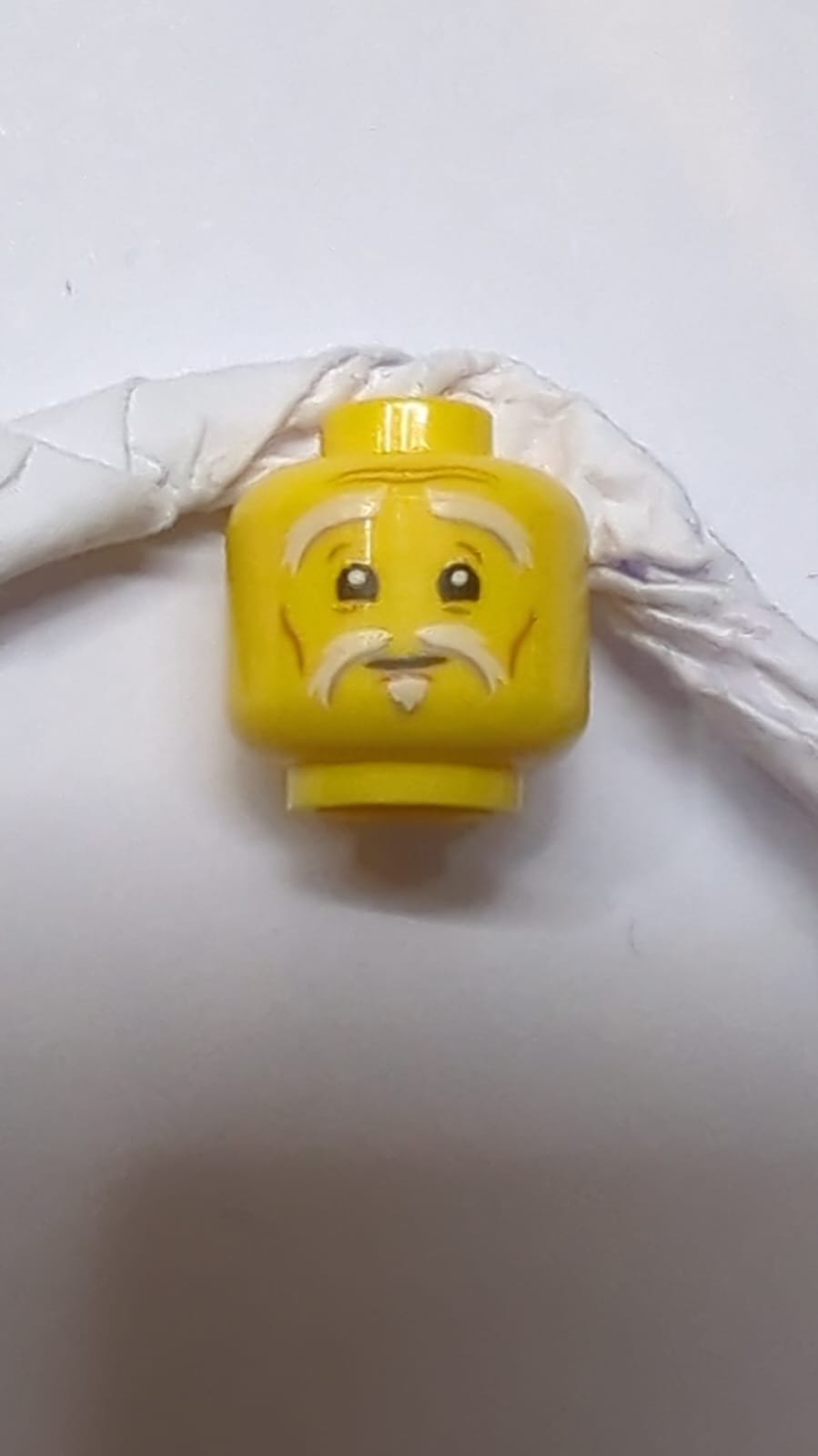 Minifigur, Kopf mit weißen buschigen Augenbrauen, Schnurrbart und Soul Patch, obere Augenlider, mittlerer Nougat-Farbton an Wangenlinien und Falten, neutrales Muster gelb
