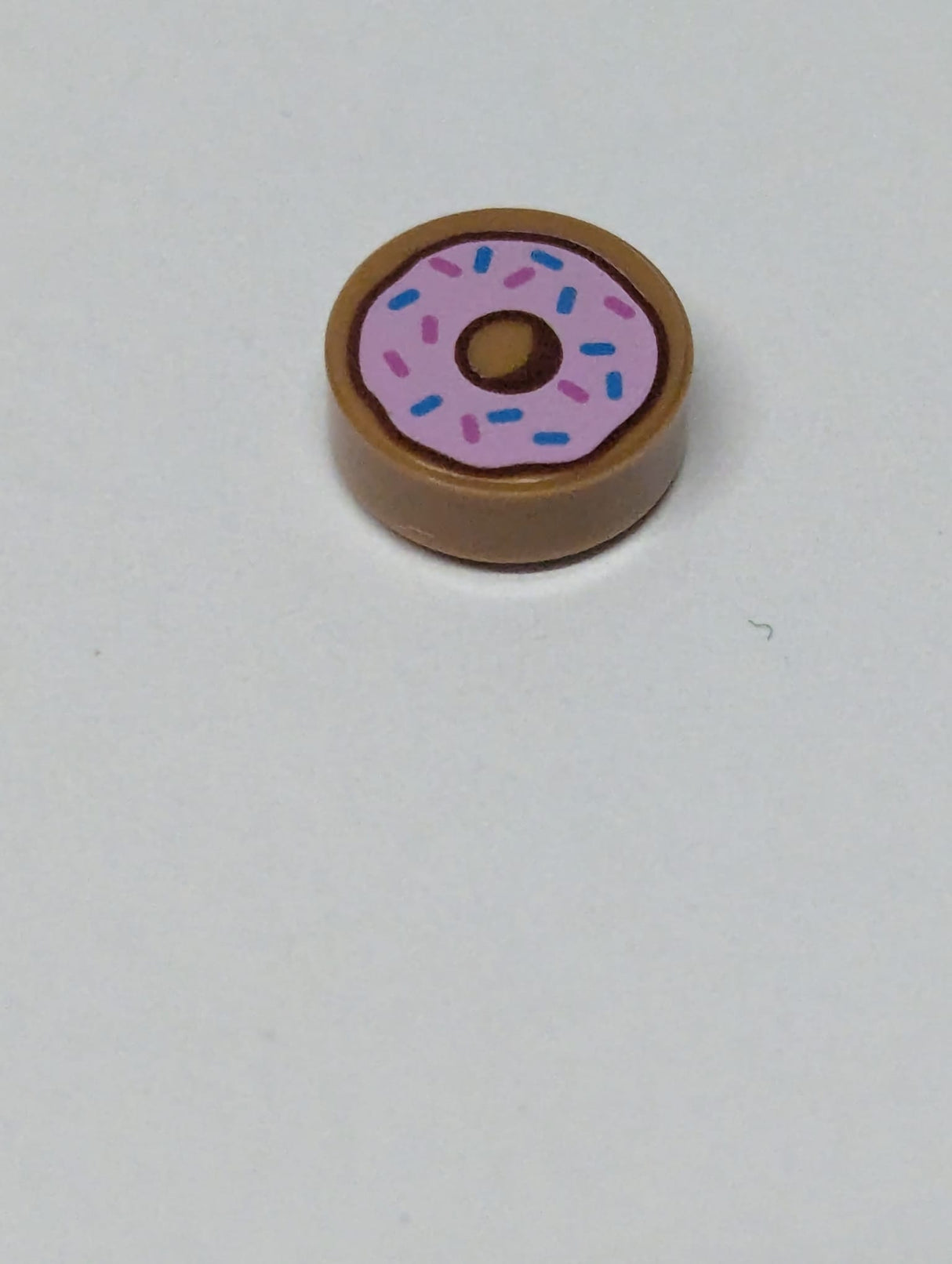 NEU Fliese, rund 1 x 1 mit Donut / Doughnut mit leuchtend rosa Glasur und Muster aus dunkelblauen und dunkelrosa Streuseln, nougat (medium)