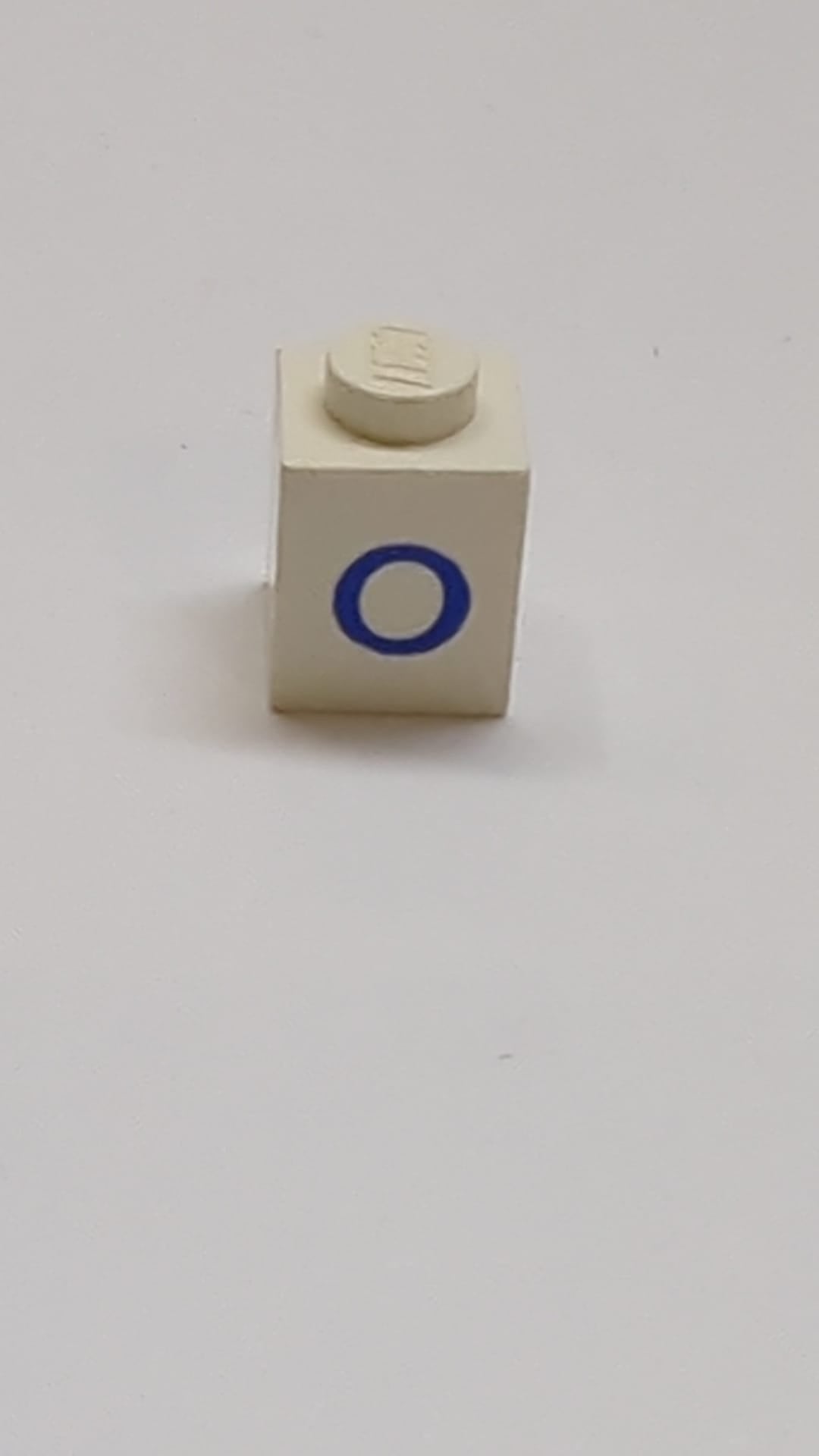 1x1 Stein mit blauem Großbuchstaben-O-Muster weiß