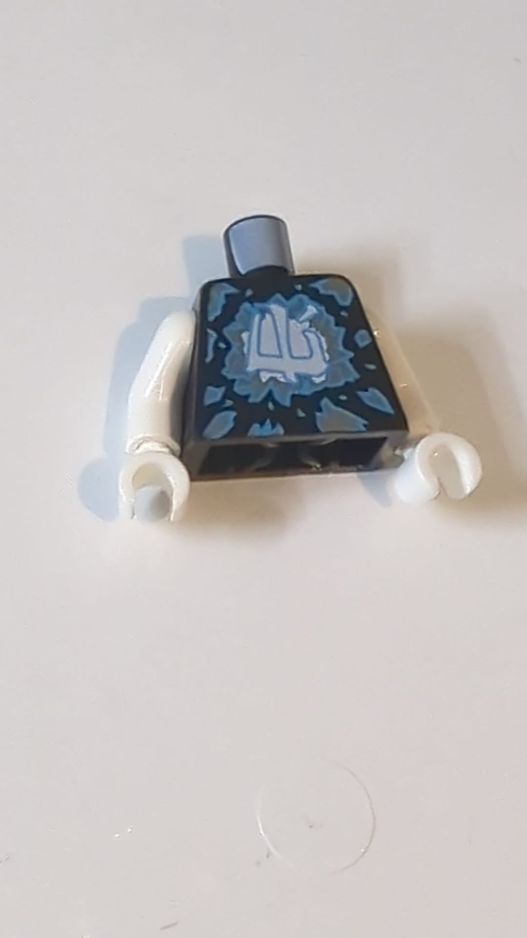 Ninjago-Torso mit dunkelblauen und silbernen Splittern und weißem Ninjago-Logogramm „Eismuster“ / Weiße Arme / Weiße Hände schwarz