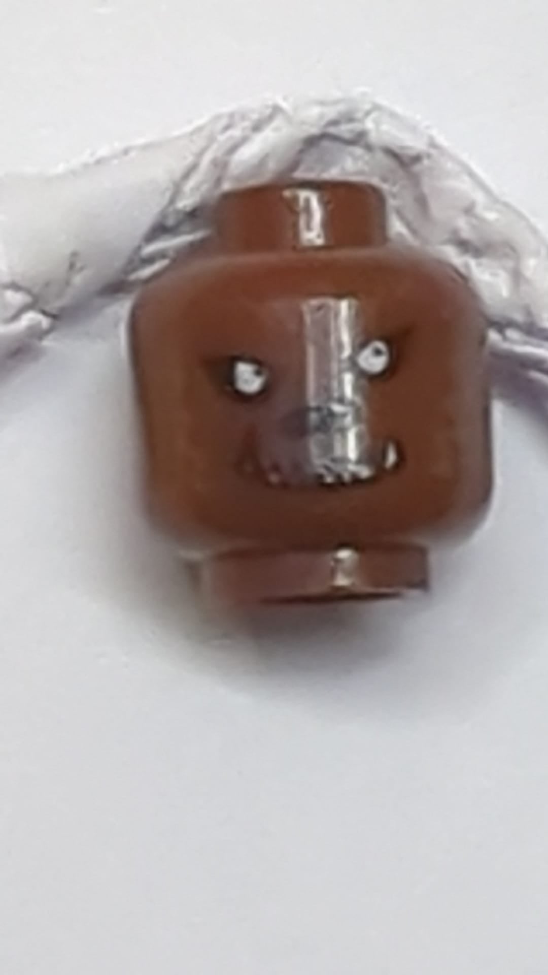 Minifigur, Werwolfkopf, dunkelbraunes Fell, schwarze Augenklappen, Nase und Grinsen mit weißem, gezacktem Fangmuster neubraun