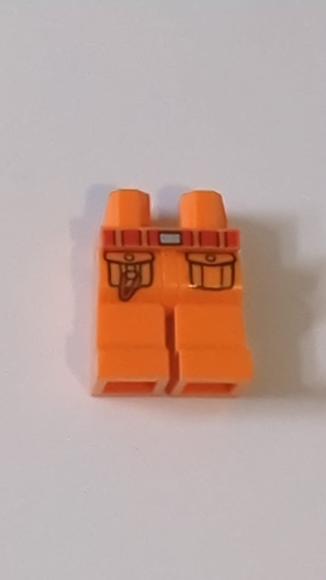 NEU Hüften und Beine mit rotem Gürtel mit silberner Schnalle, schwarze Taschenumrisse mit Karabinermuster "BAM" orange