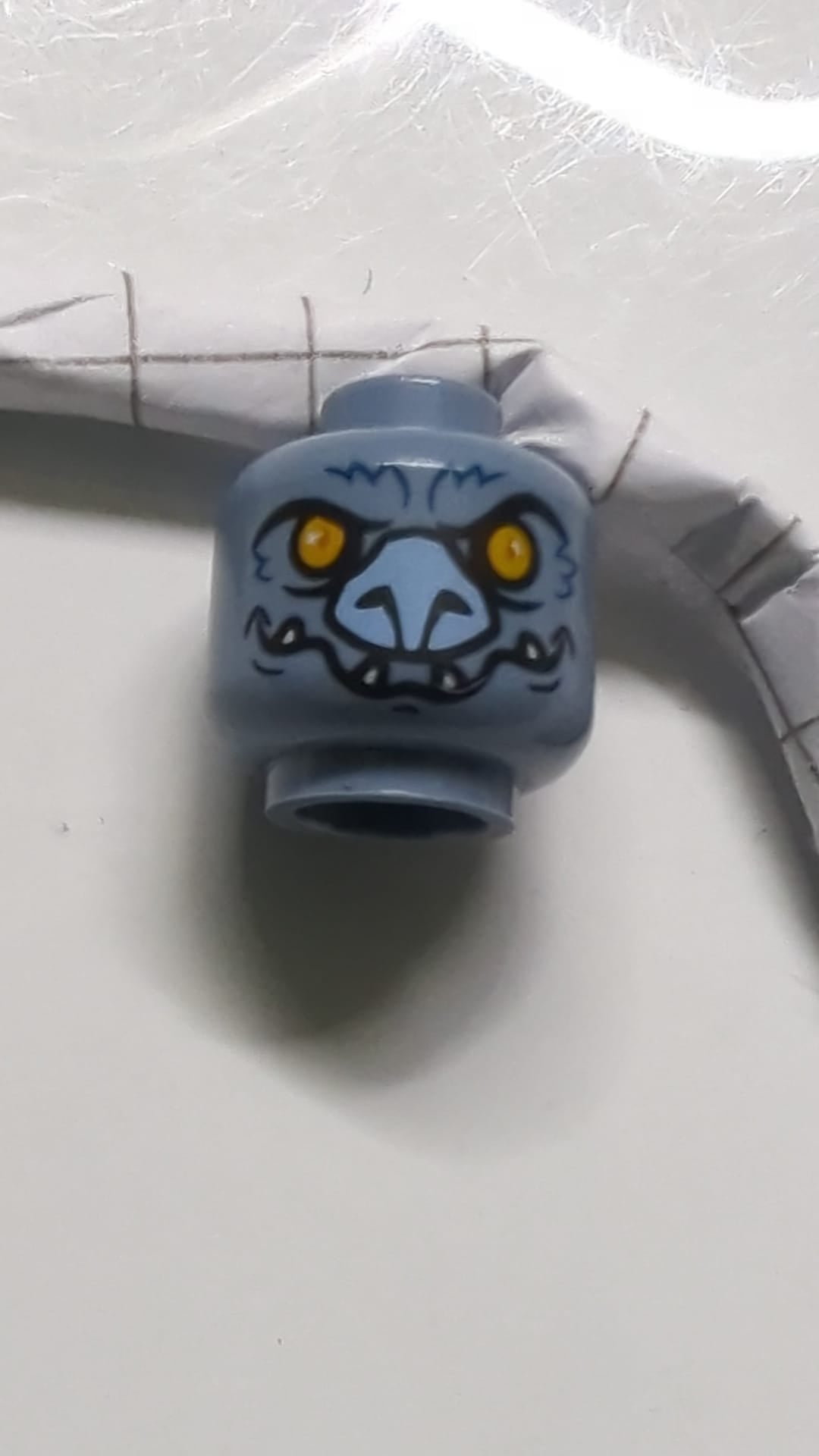 Minifigur, Kopf einer außerirdischen Chima-Fledermaus mit leuchtend orangefarbenen Augen, lavendelfarbener Nase, dunkelblauen Fellstreifen und weißem Fangmuster sandblau
