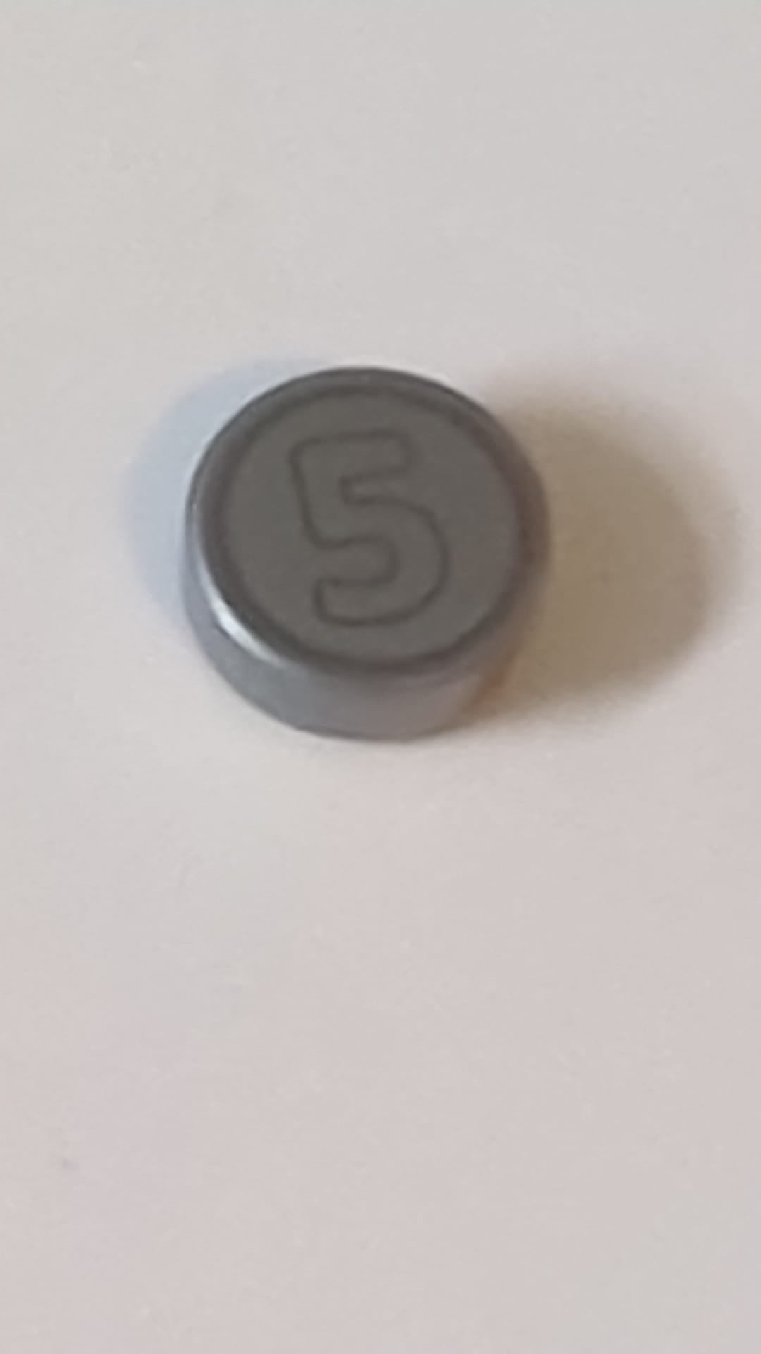 1x1 Fliese, rund, mit dunkelbläulich-grau umrandeter Ziffer 5 auf silbernem Münzmotiv-Hintergrund pearlsilber