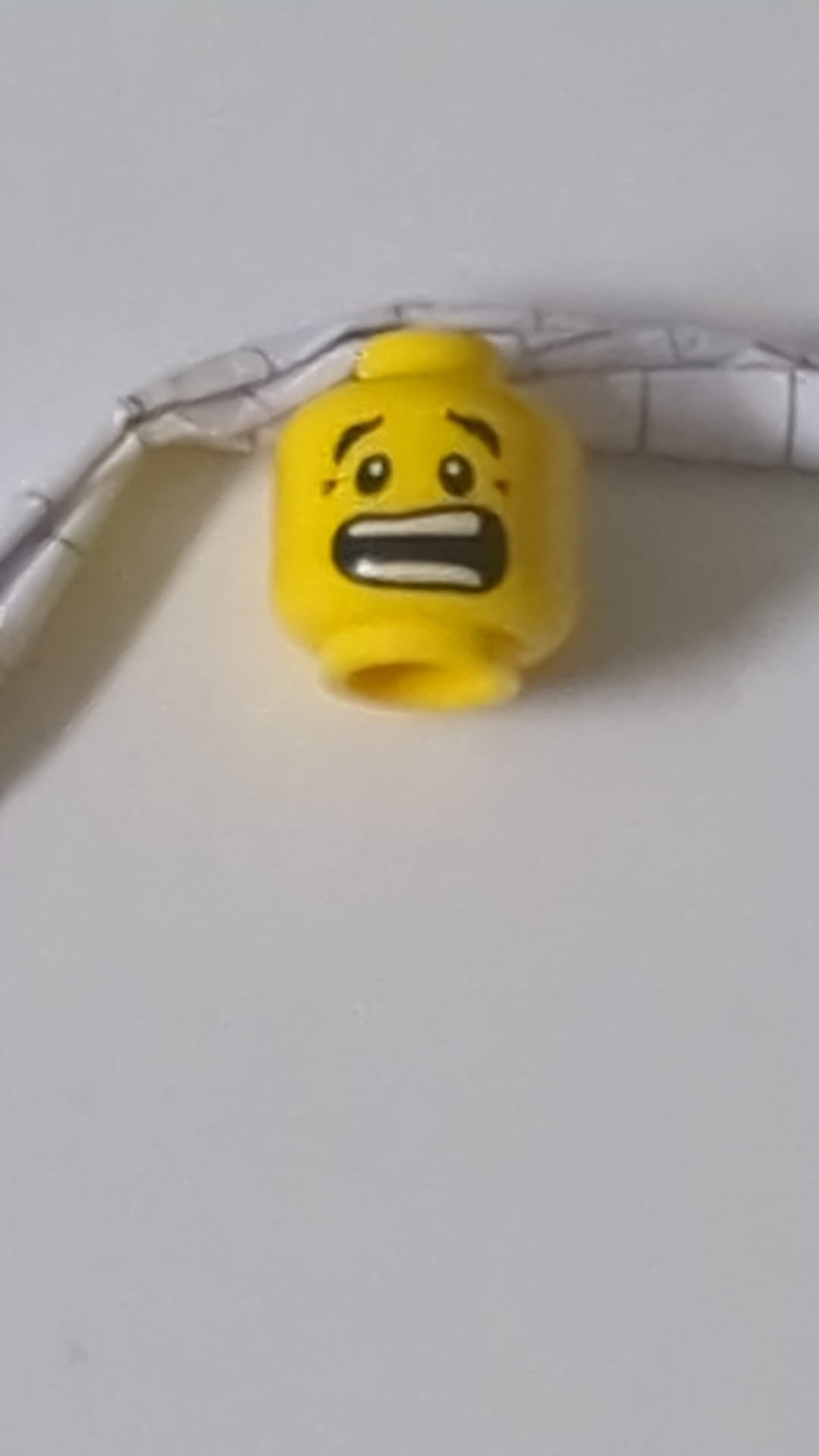 Minifigur, Kopf mit doppelseitigen schwarzen Augenbrauen, strenger Blick mit nougatfarbenem Grübchen am Kinn / ängstlicher, offener Mund mit gespreizten Zähnen gelb
