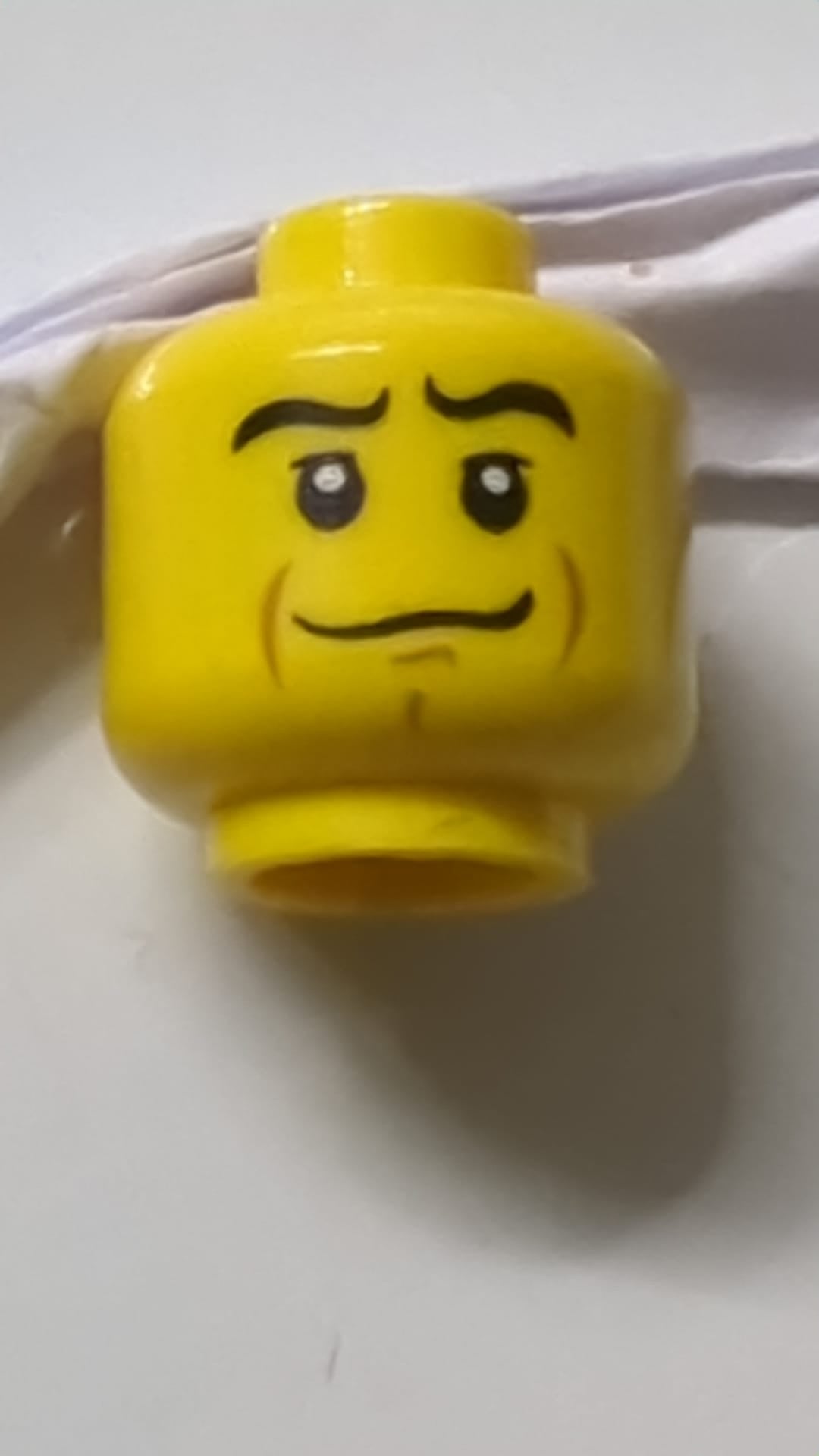 Minifigur, Kopf schwarz, gewellte Augenbrauen, mittlere Nougat-Wangenlinien und Kinngrübchen, Muster eines krummen Lächelns gelb