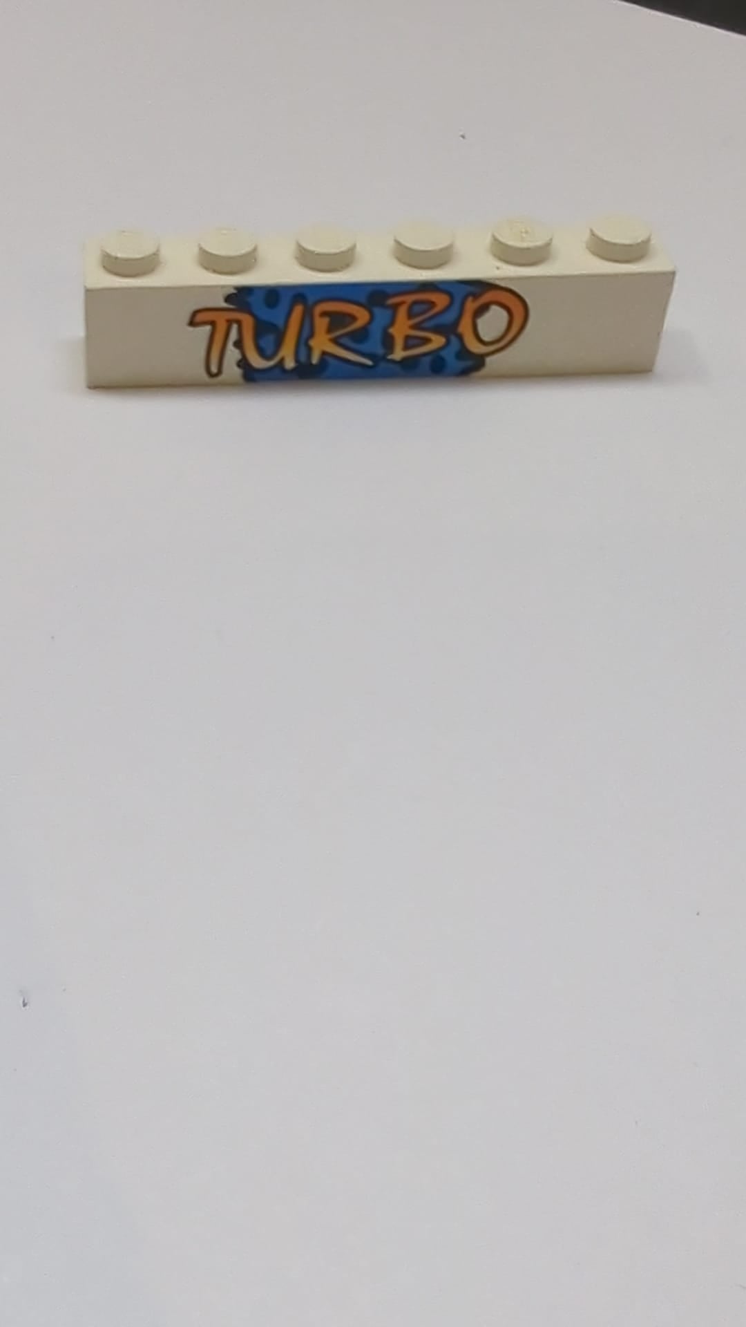 1x6 Stein mit gelbem „TURBO“-Schriftzug auf blauem Hintergrund und schwarzem Punktmuster weiß