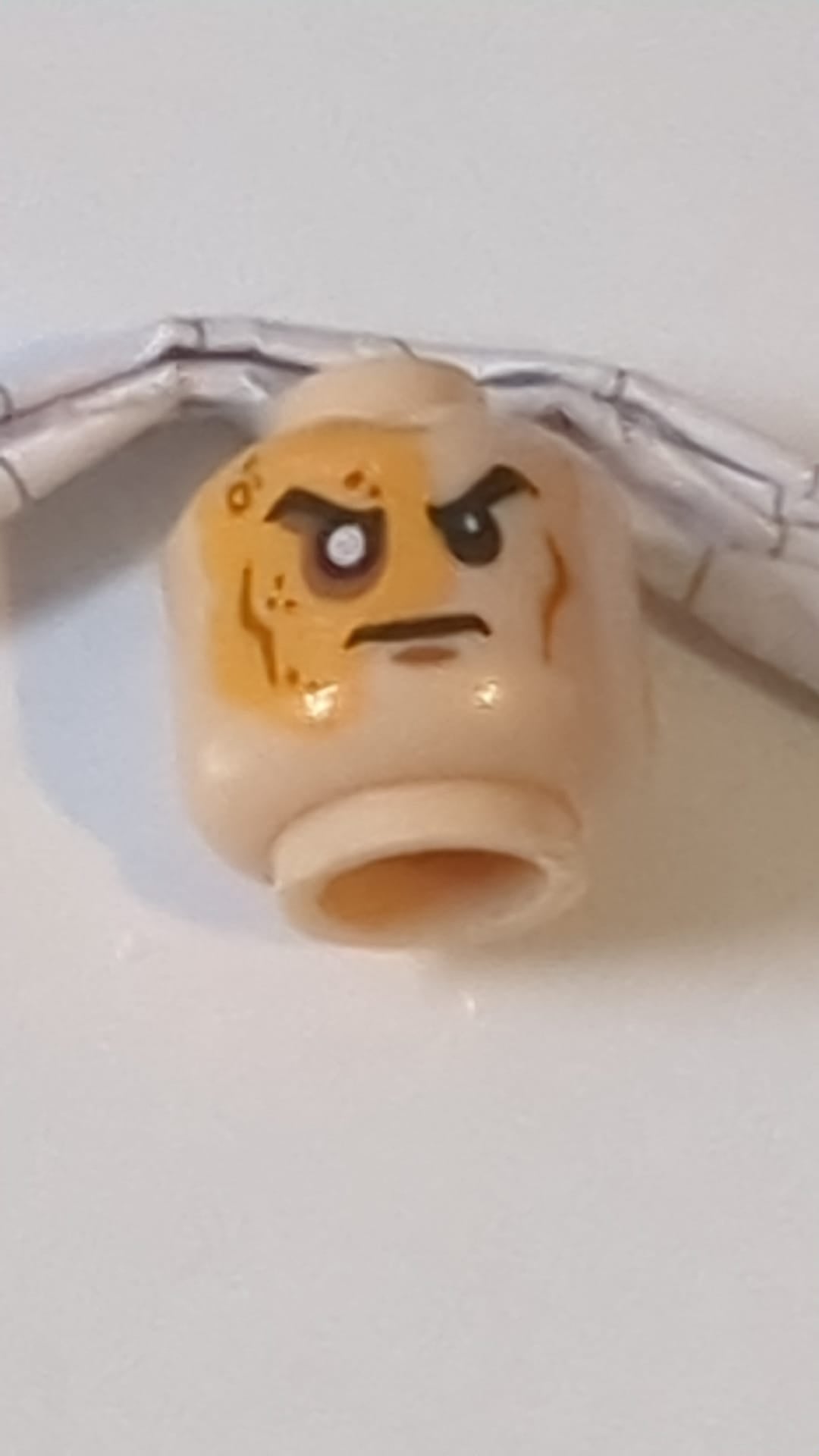 Minifigur, Kopf männlich, rechtes Auge vernarbt und ohne Pupille, festgelegtes Muster „Shredder“ hellnougat (fleischfarben)