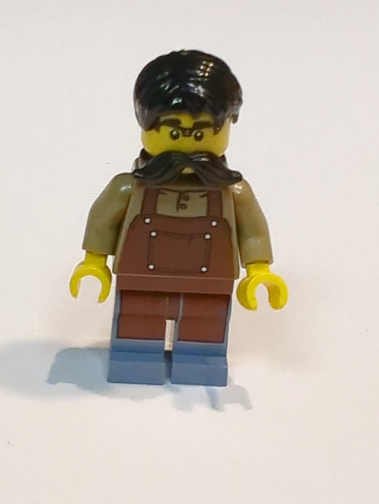 NEU Town Minifigur Tudor House Uhrmacher - Dunkelbraunes Hemd mit rotbrauner Schürze, sandblauen Beinen, schwarzen Haaren und Schnurrbart twn515