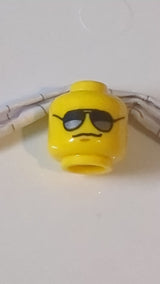 Minifigur, Kopf mit Brille (schwarz-silberne Sonnenbrille), mittelgroßes nougatfarbenes Kinngrübchen, Grinsenmuster gelb