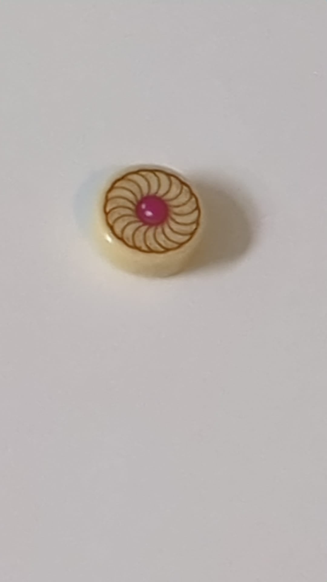 1x1 Fliese rund mit Muster (Magenta-farbener Keks in der Mitte) beige