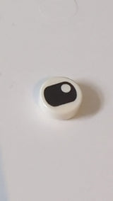 1x1 Fliese rund mit schwarzem, zusammengekniffenem Auge und vertikal zentrierter Pupille weiß
