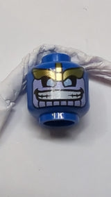 Minifigur, Alienkopf mit goldenen Augenbrauen, lavendelfarbenem Gesicht mit breitem Grinsen und goldenem Streifen auf dem Rückenmuster blau