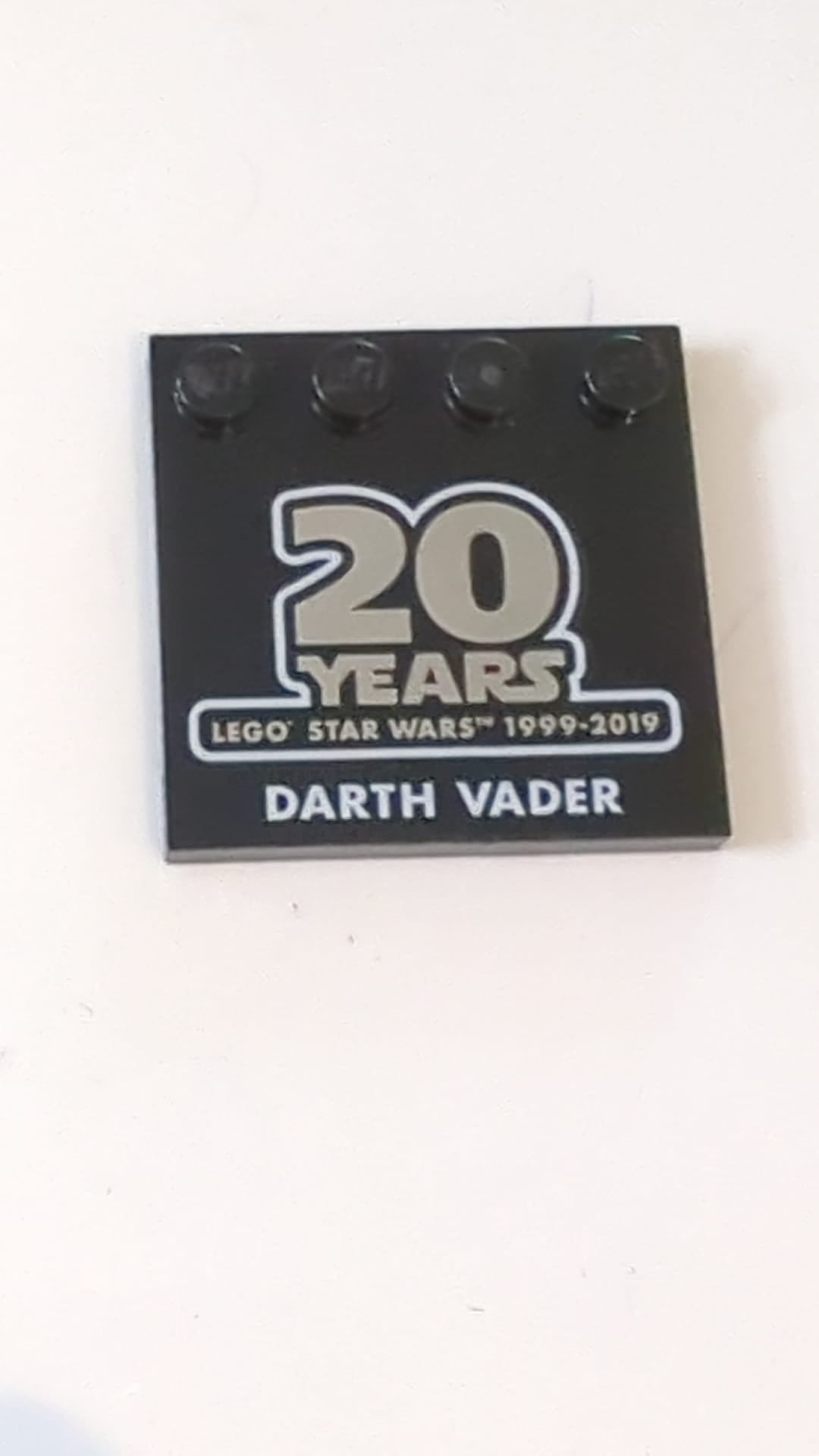 4x4 Fliese, modifiziziert mit Noppen an der Kante mit dem Aufdruck „20 YEARS LEGO STAR WARS 1999–2019“ und dem Muster „DARTH VADER“ schwarz