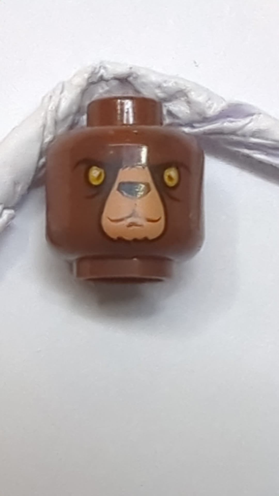 Minifigur, doppelseitiger Alien-Chima-Bär-Kopf mit leuchtend orangefarbenen Augen, schwarzer Nase, nougatfarbener Schnauze und dunkelbraunen Fellstreifen, strenges/verwirrtes Muster neubraun