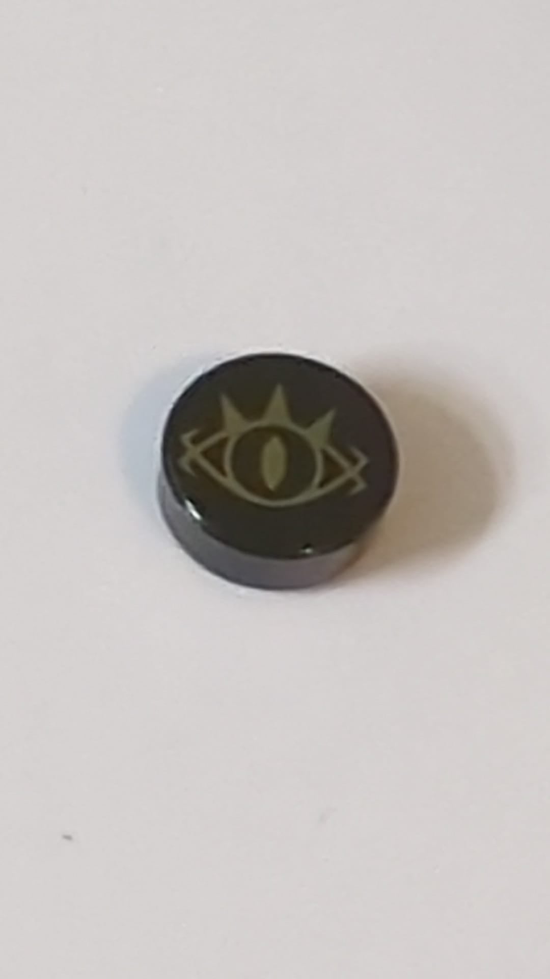 1x1 Fliese, rund,  mit Gold-Goblinkönig-Augenlogo (Muster mit stacheligen Wimpern und Schlitzpupille) schwarz