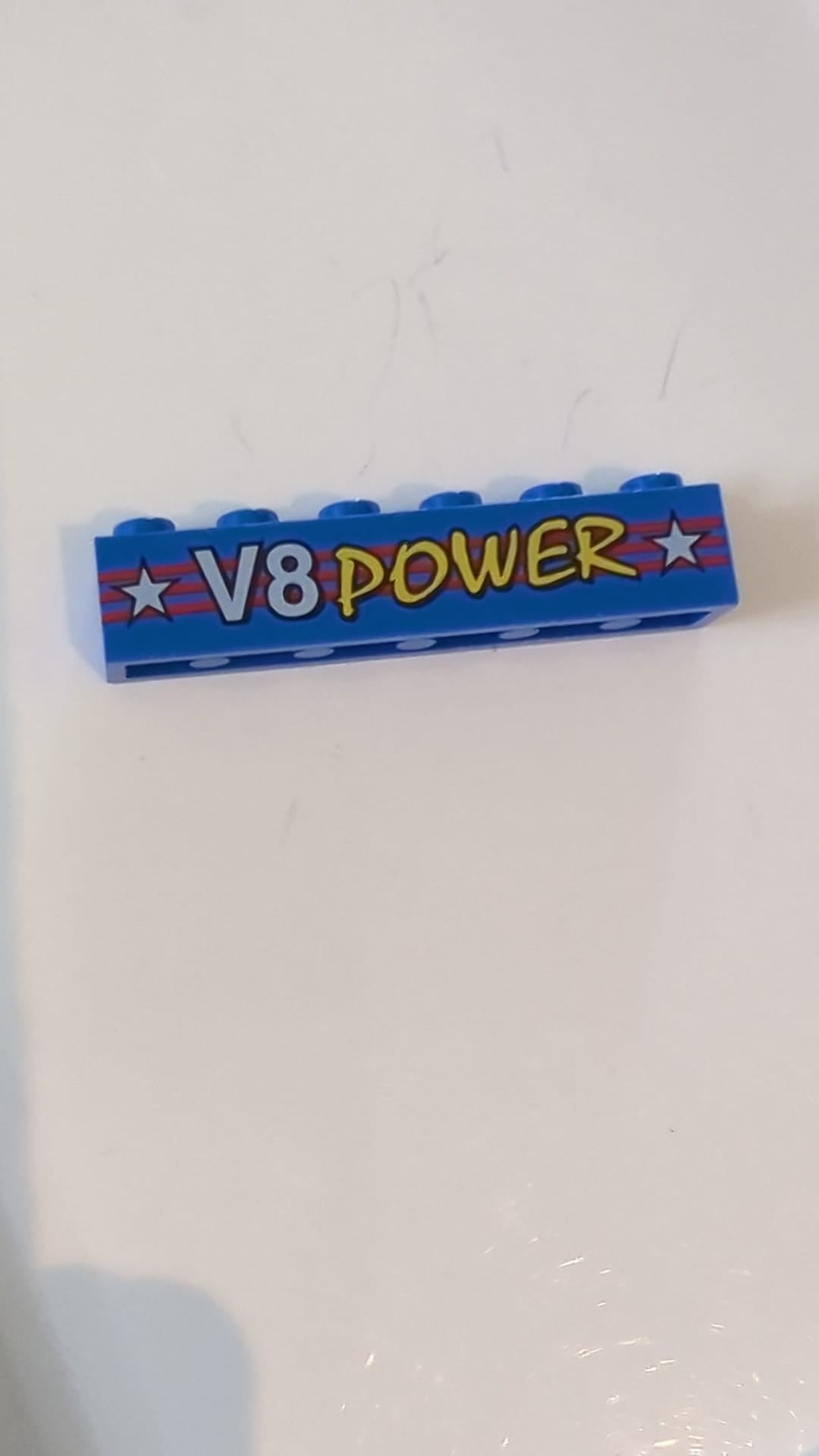 1x6 Stein mit weißem und gelbem „V8 POWER“-Schriftzug und Sternen auf rotem Streifenmuster blau