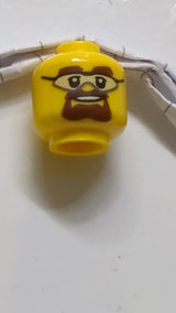 Minifigur, Kopf mit Schutzbrille, braunen Augenbrauen und Spitzbartmuster gelb