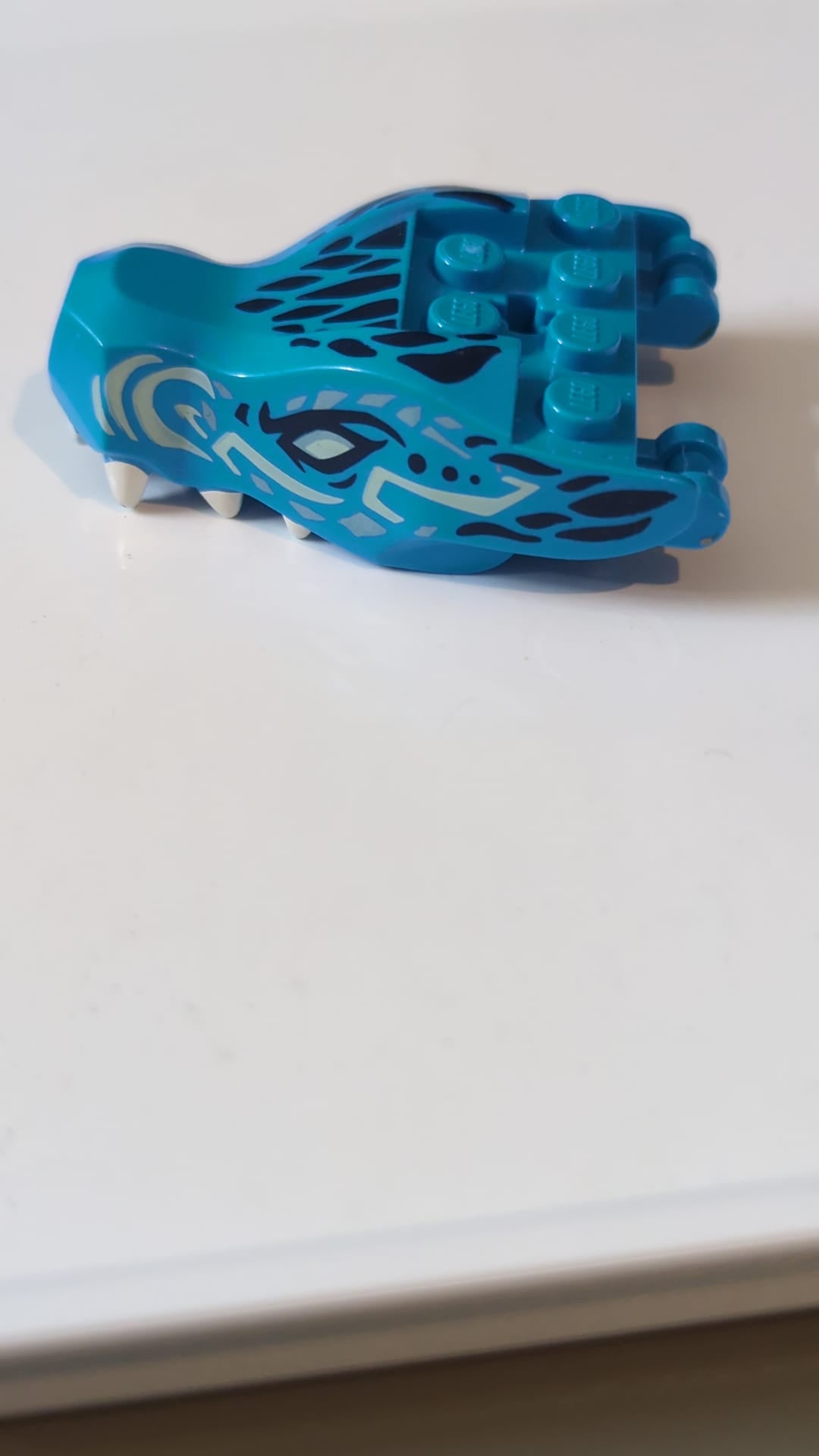 Drachenkopf „Ninjago“ mit Kiefer und zwei Griffen auf der Rückseite, helltürkisen Augen, weißen Zähnen und einem Schuppenmuster in Dunkelblau und Metallic-Hellblau dunkelazur