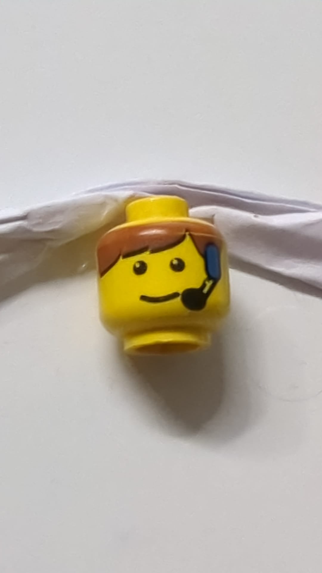 Minifigur, männlicher Kopf mit braunem Pony und Headset-Muster gelb