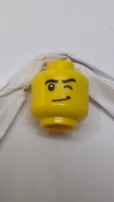 Minifigur, Kopf: schwarze Augenbrauen, linkes Auge zwinkert, schiefes Grinsen mit Grübchenmuster gelb