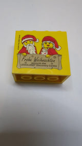 2x4x3 Stein mit dem Muster „Frohe Weihnachten wünscht das Legoland Discovery Center“ gelb