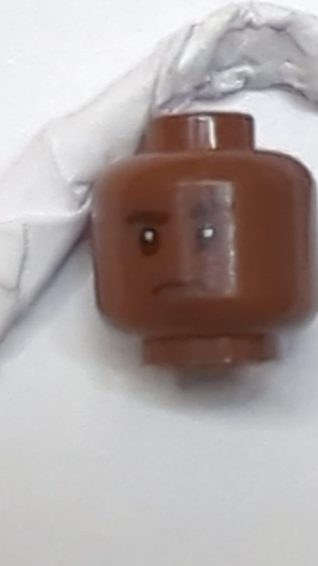 Minifigur, Kopf: Schwarze, dichte Augenbrauen, links angehoben, rechts eingekerbt, dunkelbraunes Grübchen am Kinn, leichtes Stirnrunzeln neubraun