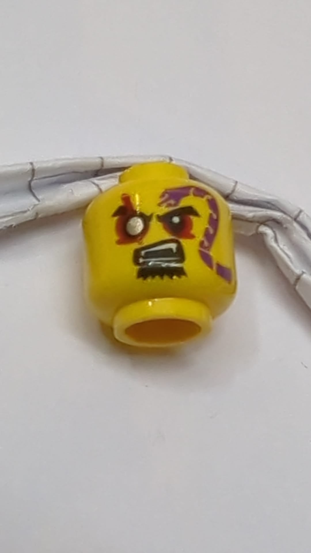 Minifigur, Kopf: Schwarze Augenbrauen, rote Augen mit silberner Pupille rechts, Spitzbart, lila Schlangen-Tattoo, offener Mund mit Fangzahnmuster gelb