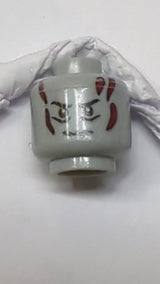 Minifigur, Kopf: Dunkelblaugraue Augenbrauen, Falten unter den Augen, Grübchen und Narben am Kinn, Dunkelrote Brandwunden, Zornesfalte neuhellgrau