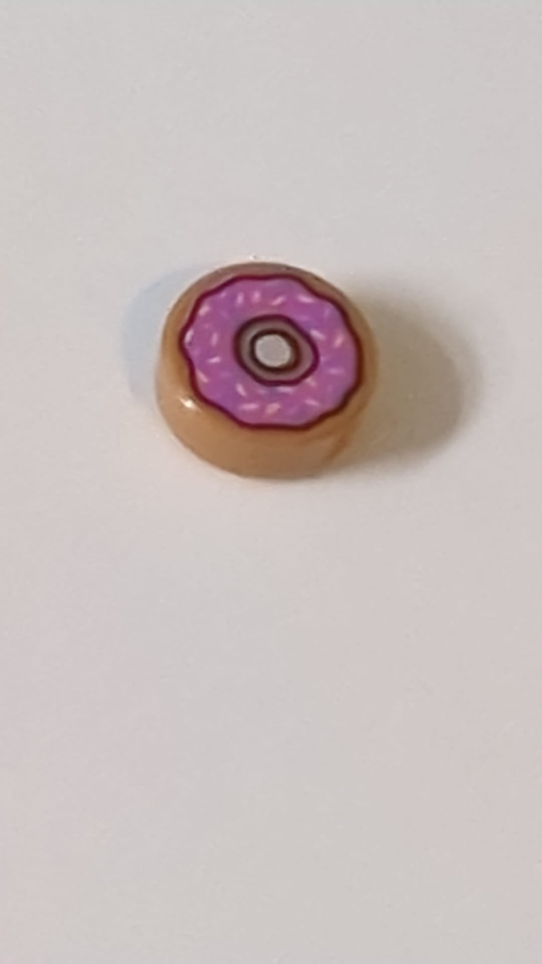 1x1 Fliese, rund Donut-Motiv mit leuchtend rosa Glasur sowie Streuseln in Dunkelazur und Dunkelrosa nougat (medium)