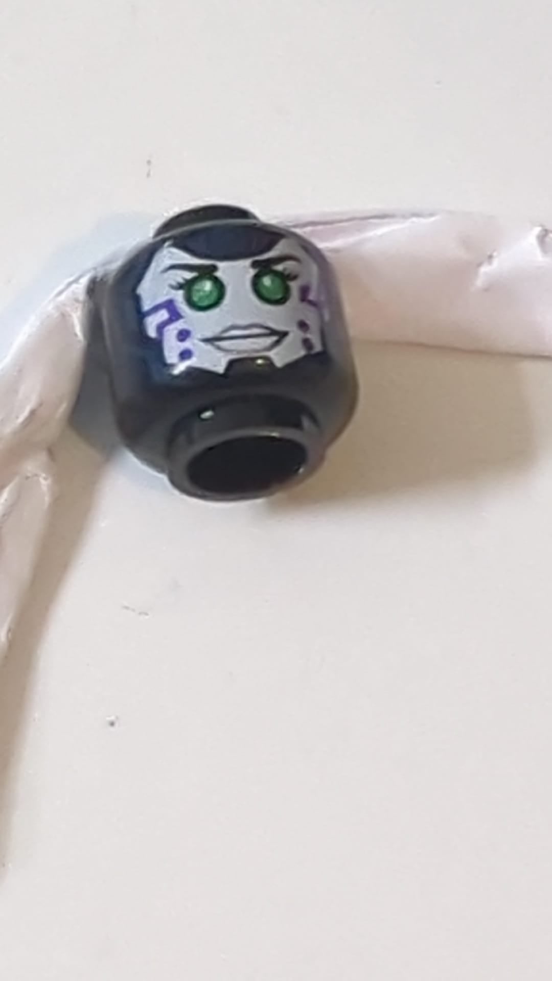 Minifigur, Kopf doppelseitig: Alien-Weibchen mit weißem Gesicht, grünen Augen und violetten Markierungen auf der Wange / rot-silbernes Rüstungsmuster schwarz