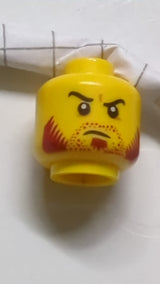 Minifigur, Kopf mit doppelseitigem Bartstoppeln, dunkelroten Koteletten, Spitzbart, geschwungenen schwarzen Augenbrauen, schiefem, offenem Grinsen / entschlossenem Gesichtsausdruck gelb