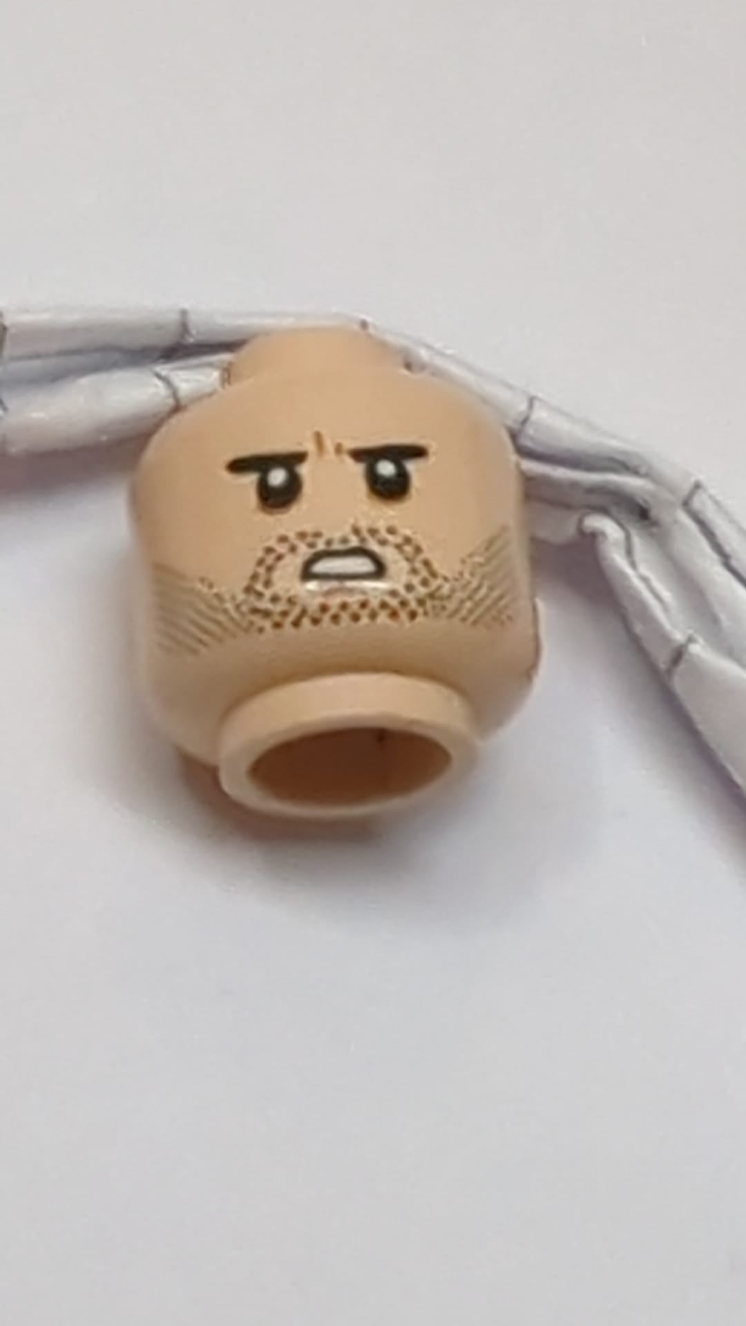 Minifigur, Kopf: Doppelseitige dunkelbraune Augenbrauen, schwarzer Bartschatten, leichtes Grinsen/Feindseligkeit mit zusammengebissenen Zähnen hellnougat (fleischfarben)