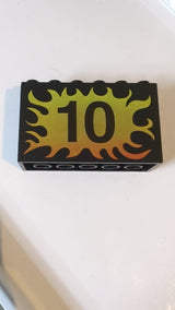 2x6x3 Stein mit der Zahl '10' auf gelb-rotem Flammenmuster schwarz