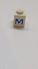 1x1 Stein mit blauem Großbuchstaben-M-Muster weiß