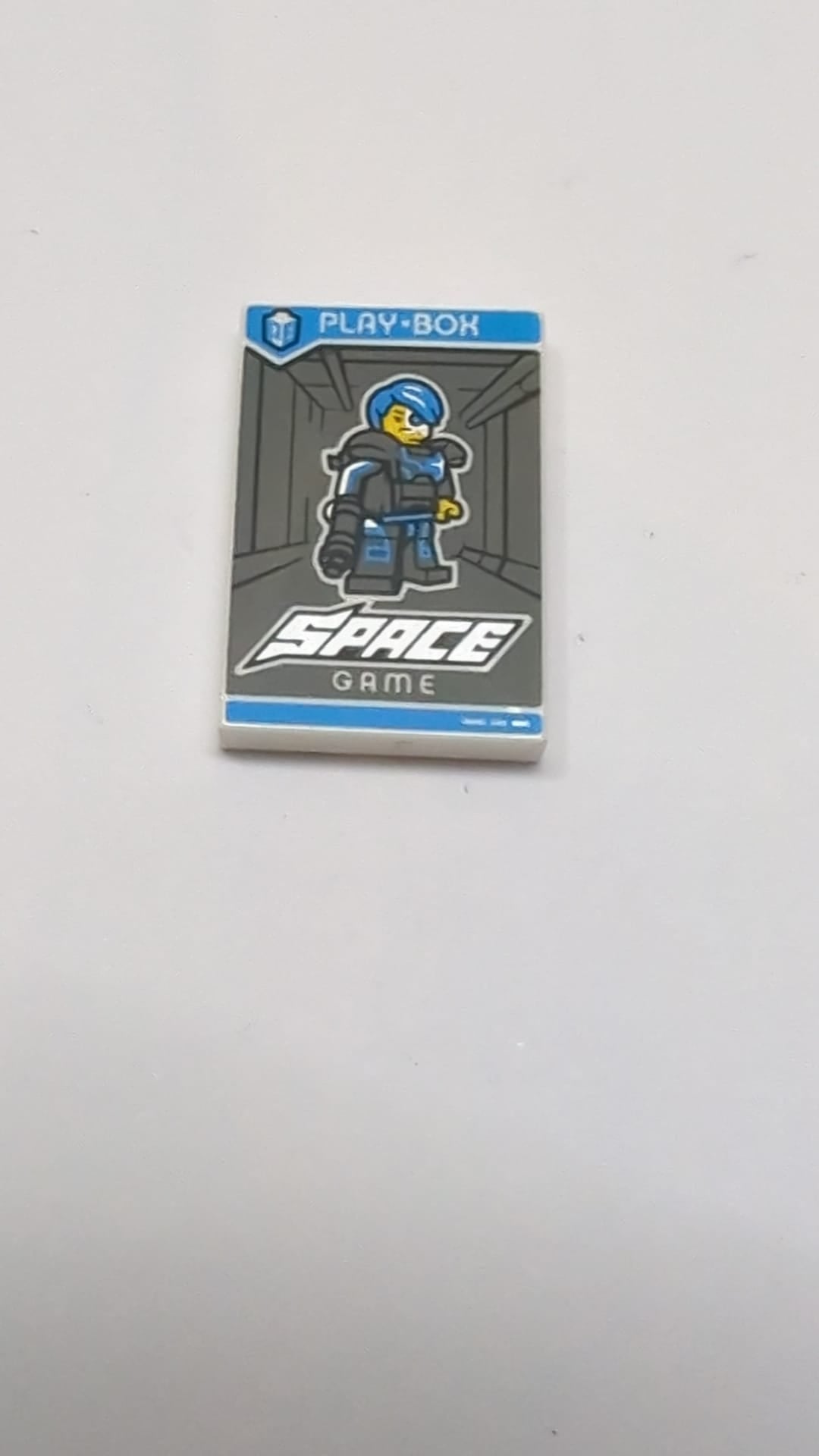 2x3 Fliese mit „SPIELBOX“, „WELTRAUMSPIEL“ und Sammelfiguren Serie 16 Cyborg-Muster weiß
