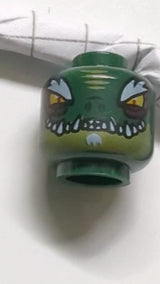 Minifigur, doppelseitiger Alien-Chima-Krokodilkopf mit leuchtend orangefarbenen Augen, olivgrünem Unterkiefer, buschigen weißen Augenbrauen, Kinnbart und scharfen Zähnen, breites/schmales Augenmuster dunkelgrün