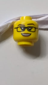 Minifigur, weiblicher Kopf, schwarze Brille, dunkelbraune Augenbrauen, mittelbraune Lippen und offenes Lächeln mit sichtbaren Zähnen gelb