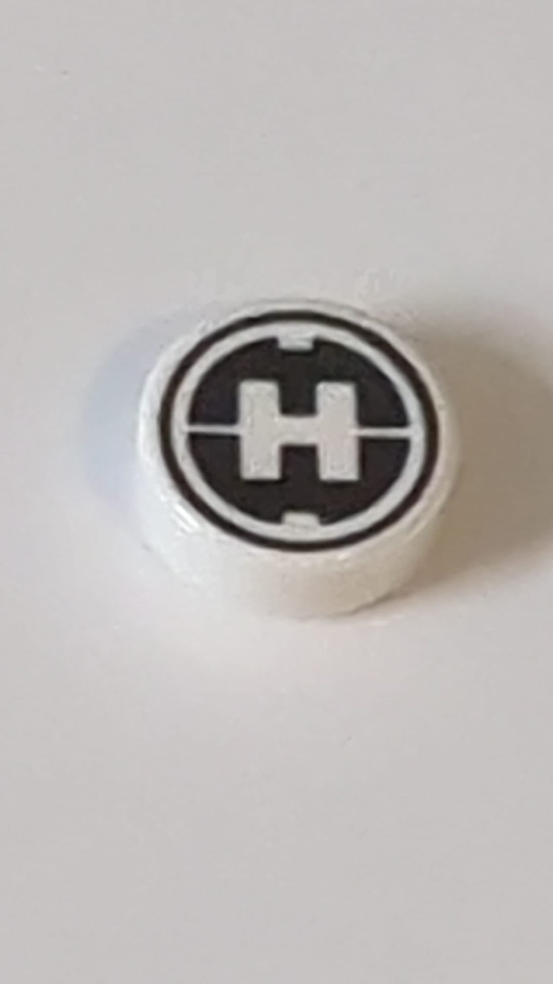 1x1 Fliese rund mit Hero Factory „H“-Muster weiß