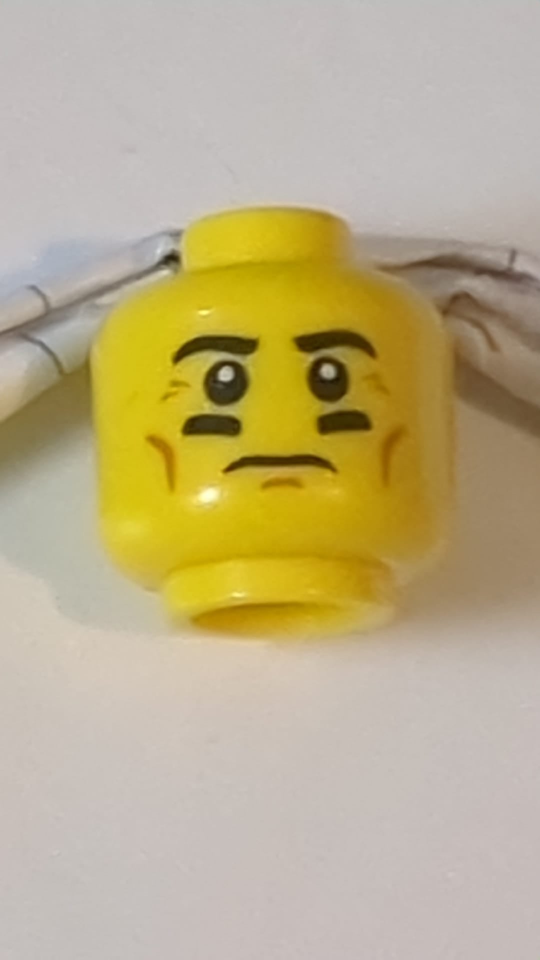 Minifigur, männlicher Kopf mit schwarzen Augenbrauen, Wangenfalten und schwarz unterstrichenem Augenmuster gelb