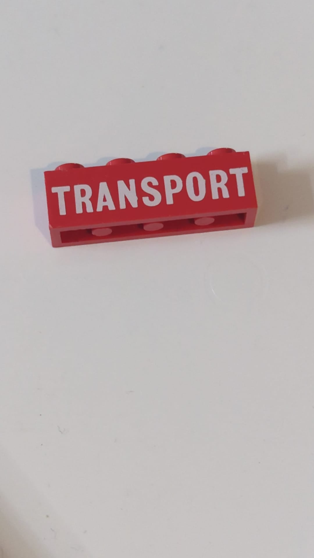 1x4 Stein mit weißem, vollflächigem „TRANSPORT“-Aufdruck rot